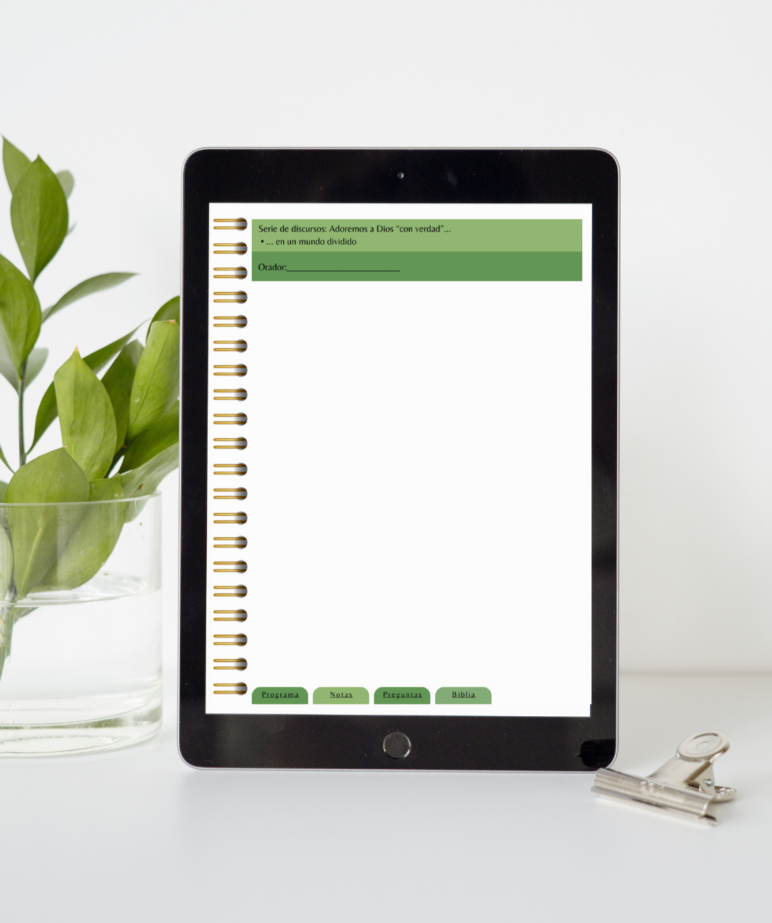 Tablet displaying a digital document on a white surface with a plant in the background