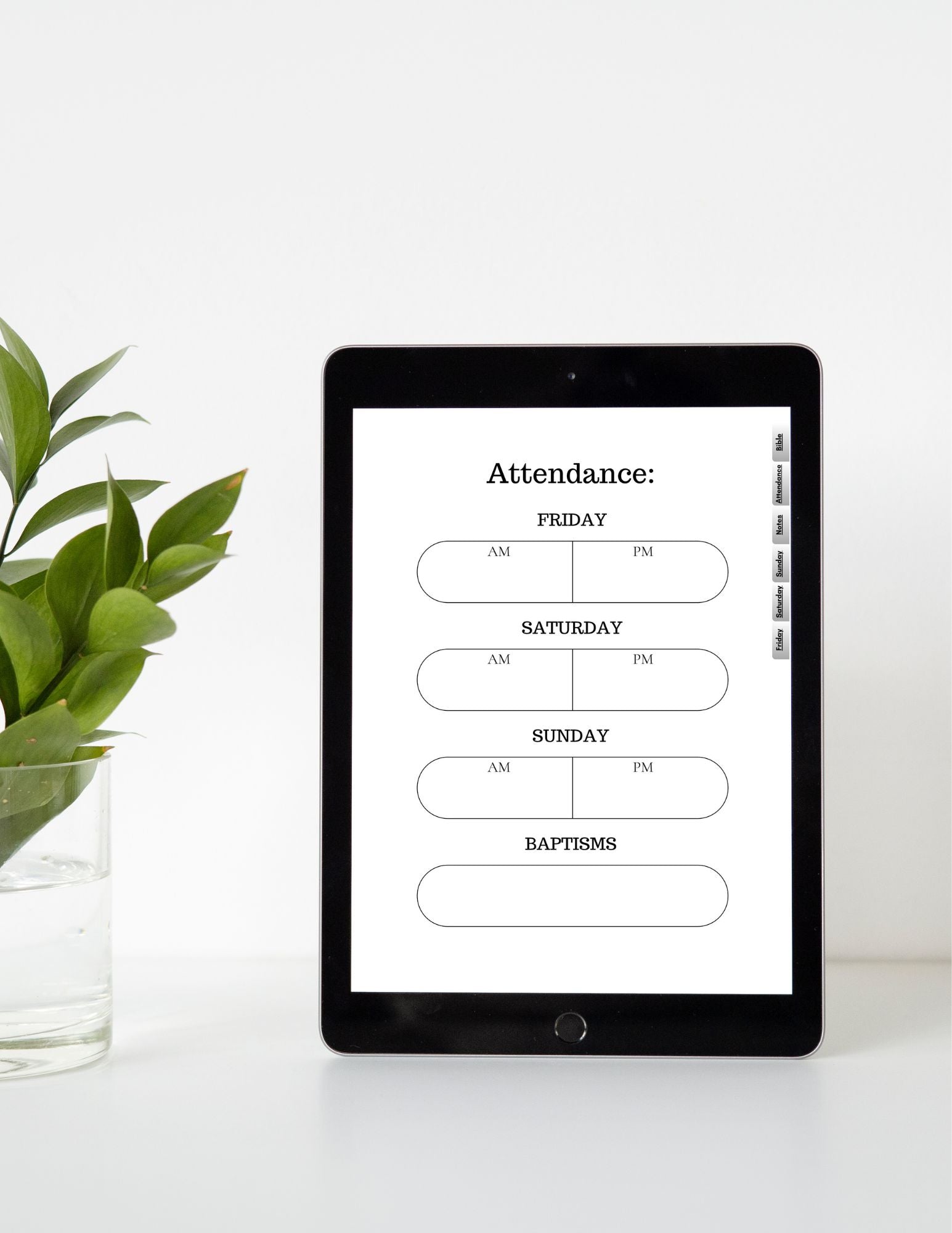 iPad displaying an attendance schedule on a white surface with a plant.